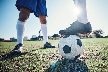 Legs, soccer and ball with players ready for kickoff on a sports field during a competitive game closeup. Football, fitness and teamwork on grass with a team standing in boots to start of a matchの写真素材