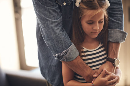 Love will keep the blues away. an adorable little girl looking sad and being comforted by her father...