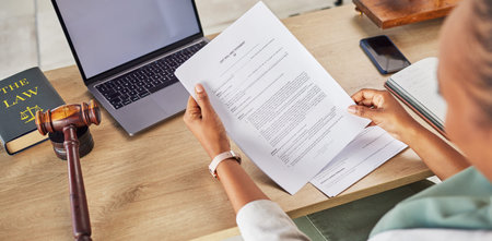 Woman, hands and lawyer reading will or documents for court judge or justice on office desk above....