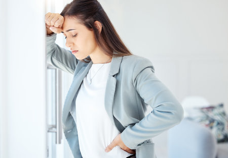 You are stronger than your challenges. a young businesswoman looking overwhelmed in an office at work.の写真素材