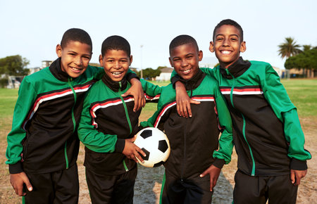 Soccer teaches kids skills such as teamwork and perseverance. Portrait of a boys soccer team standing together on a sports field.の写真素材
