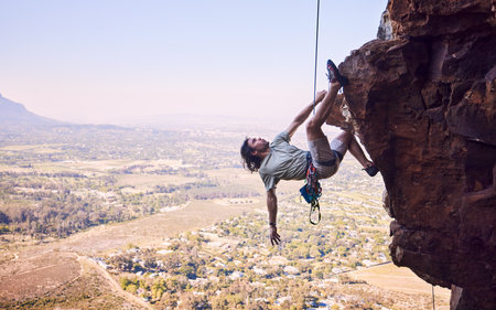Sports, rock climbing and rope with man on mountain for fitness, adventure and challenge. Nature, workout and hiking with person training on cliff for travel, freedom and exercise mockup spaceの写真素材