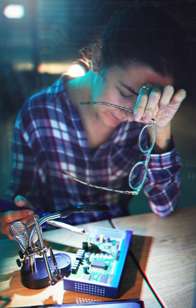 Woman, technician and pc motherboard with electronics, circuit and tired with holographic overlay in lab. Information technology, maintenance and engineer with fatigue, hardware and system in nightの写真素材