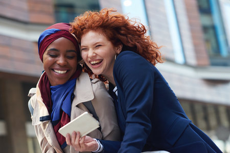 Business, women and friends in city, smartphone and happiness on lunch break, promotion and laughing. Female employees, happy consultants and agents with cellphone, outdoor and cheerful in streetの写真素材