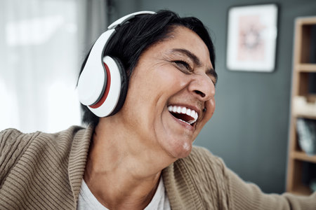 Headphones, face or happy woman streaming music or dancing to relax with freedom at home. Retirement, smile or excited senior person laughing or listening to a radio song or audio on subscriptionの写真素材