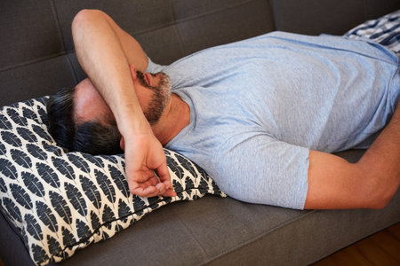 Not one of his best mornings. High angle shot of a mature man looking exhausted while lying on a...