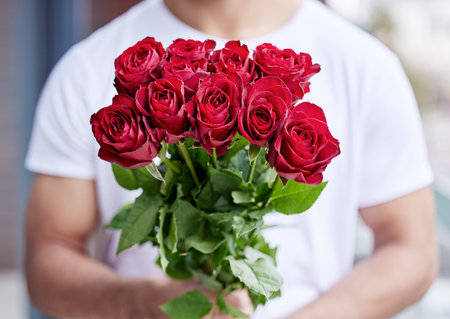 Love, romance and man with bouquet of roses for date, care for valentines day and gratitude. Romantic surprise, floral gift and person giving red flowers standing outside for proposal or engagementの写真素材