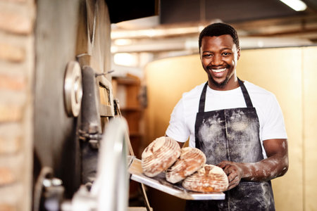 Now all you need is some butter. a male baker holding up freshly baked bread in his bakery.の写真素材