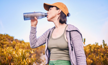 Thinking, hiking and woman drinking water in nature for wellness, health and after training....
