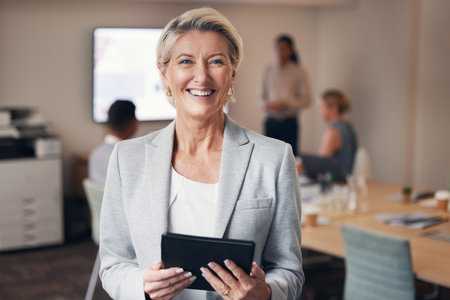 Business, portrait of mature woman with tablet and happy team leader, ceo in office with success. Leadership, smile and corporate employee, senior businesswoman boss in management at digital startup.の写真素材
