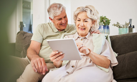 Senior couple, tablet and smile on sofa in home living room for news app, movies or streaming...