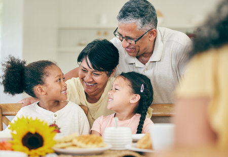 Happy, grandparents and children at table for lunch, dinner and meal together for celebration at...