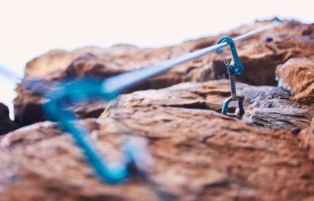 Rock climbing, mountain and closeup of rope and hook for adventure, freedom and extreme sports in...