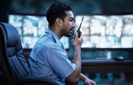 Security guard in control room, man with radio and screen to check cctv in virtual office for alarm. Safety, surveillance and agent, video to monitor crime and privacy for communication in protectionの写真素材