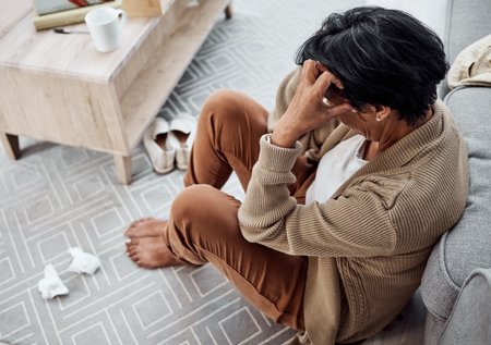 Stress, divorce or sad woman with depression, anxiety or mental health problem in house living room. Worry, cry or tired person thinking of broken heart, loss or stress from emotional grief at homeの写真素材
