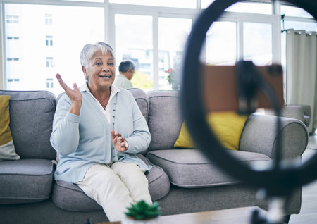 Mature woman, live stream and broadcast in home on social media, online vlog or communication to...