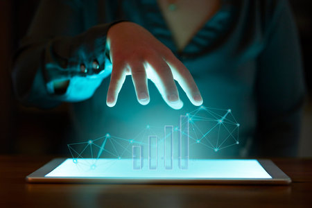 Hand, tablet and hologram graph in night at office for fintech, cybersecurity and data analytics at...