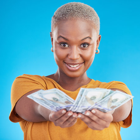 Money, offer and happy woman in portrait for success, cash and lottery choice on blue background. Face, investment and rich african person or winner with bonus, cashback and financial loan in studioの写真素材