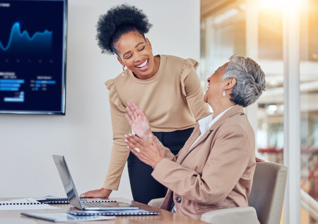 Business women, laptop and happy together for analysis, results and comic joke with finance, crypto or trading. Senior CEO, financial advisor and computer at desk for investment, coaching or laughingの写真素材