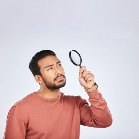 Magnifying glass, man and serious in a studio with investigation for clues. Isolated, white...
