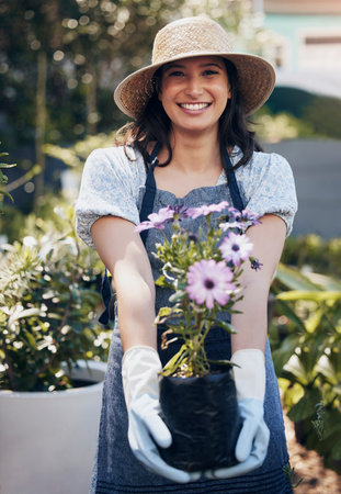 Good health and a sense of well being. a young female florist working at a nursery.の写真素材