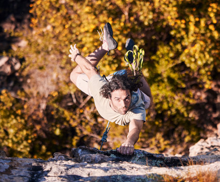 Rock climbing, explore and mountains with man in nature for sports, fitness and adventure. Workout, exercise and travel with person training on cliff for rope, challenge and performanceの写真素材