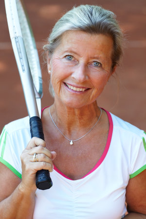 Portrait, woman and tennis player with racket for sports training, workout or game competition, exercise and fitness. Happy face of mature person or professional athlete smile for outdoor practiceの写真素材