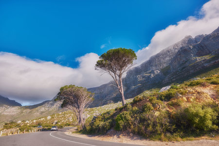 Countryside road by winding through the mountains on a scenic day. Street on the mountain with green...