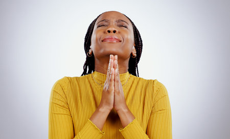 Praying, hands and black woman with stress, hope and religion with faith on white studio background....
