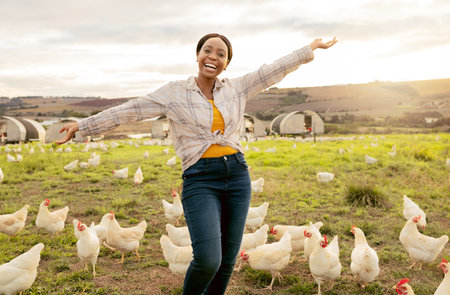 Winner, farm and chickens with a black woman agriculture worker in celebration while farming in the poultry industry. Farmer, motivation and countryside with a female agricultural expert outdoorの写真素材