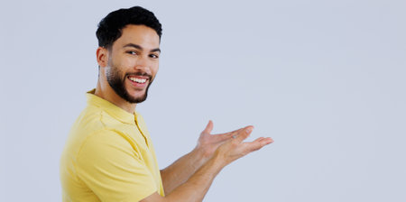 Portrait, man or advertising presentation in studio of information, deal or news about us on white background. Happy indian model show mockup space for feedback, sales promotion or launch coming soonの写真素材