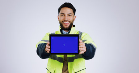 Engineering man, tablet green screen and presentation for renovation, architecture and design software in studio. Portrait of construction worker with digital technology mockup on a white backgroundの写真素材