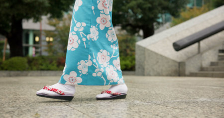 Person, Japanese and feet walking in kimono in city or local commute or traditional, outdoor or downtown. Legs, sandals and Tokyo street or urban road journey as healthy wellness, culture or tripの写真素材