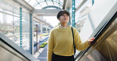 Woman, escalator and Japanese holiday or journey destination booking, airport or travel. Female...