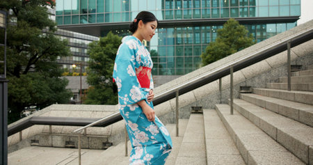 Stairs, woman and walking with traditional clothes, travel and fresh air with wellness, healthy and peace. Japanese person, city and girl with culture, movement and thinking with student and stepsの写真素材