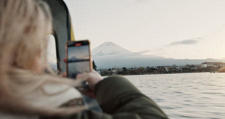 Recording, lake and woman with a smartphone, screen and vacation with network, journey and adventure. Person, outdoor and girl with a cellphone, social media and nature with digital app and exploreの写真素材