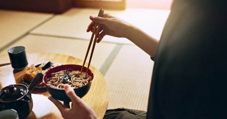 Closeup of bowl of noodles, hands and man is eating food, nutrition and sushi with chopsticks in Japan. Hungry for Japanese cuisine, soup and Asian culture with traditional meal for lunch or dinnerの写真素材