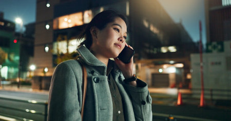 Asian woman, phone call and laughing at night in city for funny joke, conversation or outdoor travel. Happy female person smile and talking on mobile smartphone in late evening for discussion in townの写真素材