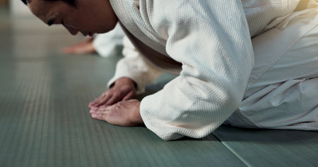 Asian man, student or bow in dojo for respect, greeting or honor to master at indoor gym. Closeup of male person or karate trainer bowing for etiquette, attitude or commitment in martial arts classの写真素材