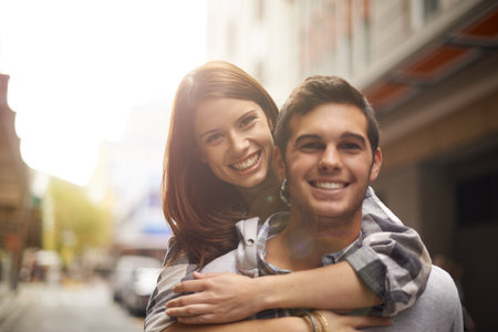 Love, portrait and happy couple hug, piggyback and together for outdoor date, bonding and fun in new city. Wellness, happiness and face of gen z man, woman or people smile for relationship commitmentの写真素材