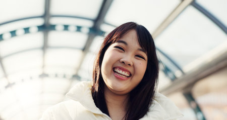 Bridge, happy and face of Japanese woman in city on commute, travel and journey in metro. Portrait, fashion and person with trendy clothes or casual style for adventure, holiday and vacation in townの写真素材