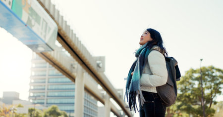 Japanese, woman and happy in city with travel in nature for morning commute, sightseeing or tourism. Person, smile and backpack in Tokyo for holiday, vacation or adventure outdoor in urban townの写真素材