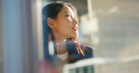 Japanese woman, thinking and city on street, travel and outdoor on vacation, direction or journey. Girl, person and holiday with vision, memory or ideas on metro sidewalk, road and sunshine in Tokyoの写真素材