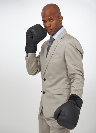 Boxing gloves, studio portrait and black man, business fighter or attorney fight injustice or government law. Battle, boxer and person for legal defence, protection or challenge on white backgroundの写真素材