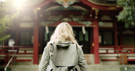 Torii gate, woman or back in japan for worship, holy or prayer location for peace in culture. Kyoto architecture, person and Fushimi Inari Taisha with religion and gateway of sacred to shinto shrineの写真素材