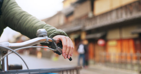 Hands, bicycle and brake handle in street, travel and transport outdoor of active rider on urban road for health. Closeup, press handlebar and person cycling to control or check bike in Kyoto Japanの写真素材