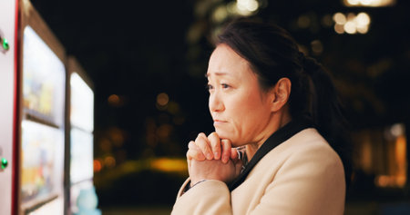 Woman, thinking and choice at vending machine for food or hot drink with in city at night. Shopping, automatic service and customer with click button and press on decision downtown in Tokyo Japanの写真素材