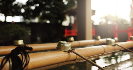 Shinto temple, closeup and fountain with water in container for faith, clean or washing hands for wellness. Religion, mindfulness or praise with purification ritual in woods, peace or shrine in Kyotoの写真素材
