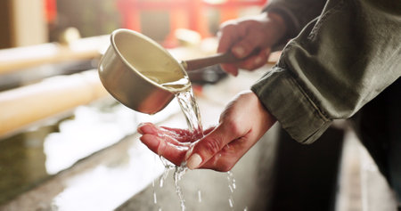 Shinto shrine, washing hands and fountain with water in container for faith, cleaning and wellness. Religion, culture and praise with ladle for purification ritual in woods, peace or temple in Kyotoの写真素材