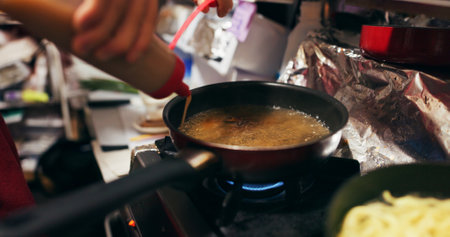 Cooking, sauce and person with pan on gas stove at food market for meal preparation, eating and nutrition. Culinary, restaurant and closeup of utensils to prepare lunch, cuisine dinner and supperの写真素材